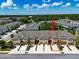 Aerial view of townhome with red arrow highlighting the property and showing parking at 6225 Scarlet Darter Way, Tampa, FL 33625