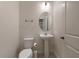 This bathroom features neutral tones, a pedestal sink, an oval mirror, and a toilet with modern fixtures at 6225 Scarlet Darter Way, Tampa, FL 33625
