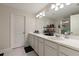 Bathroom features double sinks, a large mirror, vanity storage space, and a connected shower at 6225 Scarlet Darter Way, Tampa, FL 33625