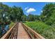 Scenic view from wooden bridge overlooking playground and covered picnic area in a tree-lined community at 6225 Scarlet Darter Way, Tampa, FL 33625