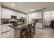 Well-lit kitchen with white cabinets, granite countertops, stainless steel appliances, and bar seating at 6225 Scarlet Darter Way, Tampa, FL 33625