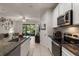 Bright kitchen open to the living area, featuring granite countertops, stainless appliances, and tile flooring at 6225 Scarlet Darter Way, Tampa, FL 33625
