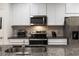 Kitchen boasts stainless steel appliances, granite countertops, and stylish white cabinetry at 6225 Scarlet Darter Way, Tampa, FL 33625
