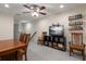 Cozy living room features a ceiling fan and a television with shelving for board games and books at 6225 Scarlet Darter Way, Tampa, FL 33625
