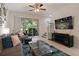 Bright living room with comfortable seating, a glass coffee table, and sliding doors leading to outdoor space at 6225 Scarlet Darter Way, Tampa, FL 33625