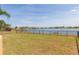 Spacious backyard bordered by a black fence and a picturesque lake view offers a peaceful outdoor retreat at 711 Parker Den Dr, Ruskin, FL 33570