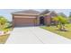 The exterior showcases a well-maintained lawn and an expansive driveway, perfect for multiple vehicles at 711 Parker Den Dr, Ruskin, FL 33570
