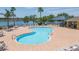 Community pool featuring a lake view, lounge chairs, palm trees and covered patio at 711 Parker Den Dr, Ruskin, FL 33570