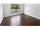 Clean, minimalist bedroom with beautiful wood floors and ample natural light from the large window at 8114 Pond Shadow Ln, Tampa, FL 33635