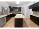 Well-lit kitchen featuring an island, dark cabinets, tile backsplash, and stainless steel appliances at 8114 Pond Shadow Ln, Tampa, FL 33635