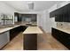 Bright kitchen featuring black cabinets, mosaic backsplash, and a center island with light countertops at 8114 Pond Shadow Ln, Tampa, FL 33635