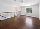 Upstairs landing with wooden floors, wood banister and a black metal railing at 8114 Pond Shadow Ln, Tampa, FL 33635