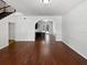 Modern living room with wood floors, archway into the kitchen, and staircase at 8114 Pond Shadow Ln, Tampa, FL 33635