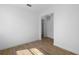 A white empty room featuring wood-look tile floors, fresh white paint, and modern light fixtures at 936 57Th N Ave, St Petersburg, FL 33703