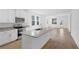 A modern kitchen with stainless steel appliances, white cabinets, and a granite island sink with a view to dining area at 936 57Th N Ave, St Petersburg, FL 33703