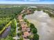 Stunning aerial view of luxury homes on lakefront property with lush greenery and tile roofs under sunny skies at 9630 Tree Tops Lake Rd, Tampa, FL 33626