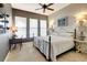 Bedroom with gray accent wall, large windows, modern furniture, and decorative lighting for a cozy ambiance at 9630 Tree Tops Lake Rd, Tampa, FL 33626