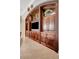 Close-up of the built-in entertainment center featuring decorative trim, cabinet space, and a modern television at 9630 Tree Tops Lake Rd, Tampa, FL 33626