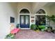 Inviting front entrance with ornate double doors, decorative bench, beautiful plantings, and brick walkway at 9630 Tree Tops Lake Rd, Tampa, FL 33626