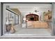 Open-concept living room featuring tile flooring, an entertainment center, and sliding glass doors to the patio at 9630 Tree Tops Lake Rd, Tampa, FL 33626