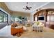 Bright living room with a ceiling fan, built-in shelving, and sliding glass doors to the outdoor patio at 9630 Tree Tops Lake Rd, Tampa, FL 33626
