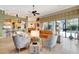 Bright living room features a ceiling fan, comfortable seating, and seamless transition to outdoor pool area at 9630 Tree Tops Lake Rd, Tampa, FL 33626