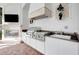 Outdoor kitchen featuring stainless steel grill, white cabinetry, and tiled backsplash with granite countertops at 9630 Tree Tops Lake Rd, Tampa, FL 33626