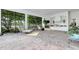 Spacious screened-in patio features a fireplace, outdoor kitchen, comfortable seating, and views of the lake at 9630 Tree Tops Lake Rd, Tampa, FL 33626
