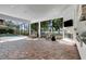 Covered patio with brick flooring, fireplace, television, and views of the pool and landscaped surroundings at 9630 Tree Tops Lake Rd, Tampa, FL 33626