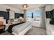 Comfortable bedroom with a large window, ceiling fan, stylish decor and natural light at 9967 Trellis Vine Way, Parrish, FL 34219