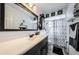 Well-lit bathroom with a large vanity, framed mirror, and shower with patterned curtain at 12901 129Th Ave, Largo, FL 33774