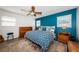 Comfortable bedroom featuring a blue accent wall, ceiling fan, and wood-look flooring at 12901 129Th Ave, Largo, FL 33774