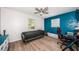 Bright bedroom with a blue accent wall, wood-look floors, and a ceiling fan at 12901 129Th Ave, Largo, FL 33774