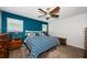 Cozy bedroom with wood-look floors, ceiling fan, and a patterned blue and white bedspread at 12901 129Th Ave, Largo, FL 33774