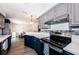 Updated kitchen features stainless appliances, white counters, blue and gray cabinets and adjacent dining space at 12901 129Th Ave, Largo, FL 33774