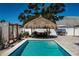 Beautiful backyard pool with a tiki hut lounge, swing and outdoor seating at 12901 129Th Ave, Largo, FL 33774