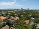 Expansive aerial view of a neighborhood with lush trees, various rooftops, and a glimpse of the ocean at 1008 S Armenia Ave # A, Tampa, FL 33629