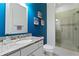 Bright bathroom with blue accent wall, granite countertop vanity, and glass-enclosed shower at 1008 S Armenia Ave # A, Tampa, FL 33629