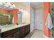 Bathroom featuring double sinks, granite countertop, and a glass-enclosed shower at 1008 S Armenia Ave # A, Tampa, FL 33629