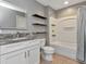 Bathroom features granite vanity top, white cabinets, a shower, and open shelving at 10121 Westpark Preserve Blvd # 10121, Tampa, FL 33625