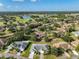 Aerial view of a residential neighborhood with mature trees and a golf course in the distance at 1016 Mcdaniel St, Sun City Center, FL 33573