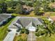 Expansive aerial view of a home with a gray roof, mature trees, and lush landscaping in a neighborhood at 1016 Mcdaniel St, Sun City Center, FL 33573