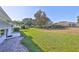 Lush backyard featuring a mix of green grass, trees, and manicured landscaping at 1016 Mcdaniel St, Sun City Center, FL 33573