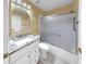 Bathroom featuring a tub shower with a glass door and stylish granite countertop and fixtures at 1016 Mcdaniel St, Sun City Center, FL 33573