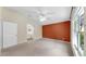 A cozy bedroom with a large window, neutral carpet, and en-suite bathroom at 1016 Mcdaniel St, Sun City Center, FL 33573
