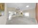 Open-concept living room with neutral tones, featuring a modern light fixture and views to other rooms at 1016 Mcdaniel St, Sun City Center, FL 33573