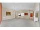 A spacious, open-concept living room featuring modern lighting fixtures and neutral carpet at 1016 Mcdaniel St, Sun City Center, FL 33573