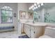 Bright bathroom with a large mirror, modern sink, and a window that overlooks the lush outdoor greenery at 10321 Shady Oak Ln, Seminole, FL 33777