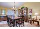 A warm dining room with decorative chandelier, wood table and chairs, and hutch at 10321 Shady Oak Ln, Seminole, FL 33777