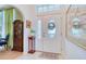 Bright foyer featuring a decorative front door with tiled flooring and arched entrance to living area at 10321 Shady Oak Ln, Seminole, FL 33777